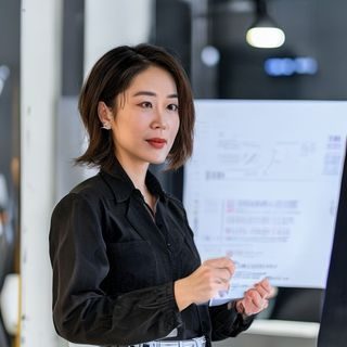 林晓雯，鬼父在线产品总监，短发干练造型，在白板前讲解产品规划，专注而充满激情